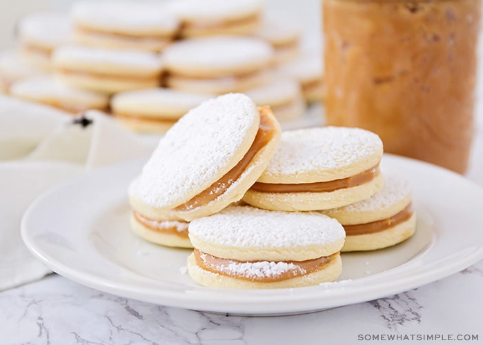 a plate of homemade alfajores with powdered sugar on a table made using this easy recipe